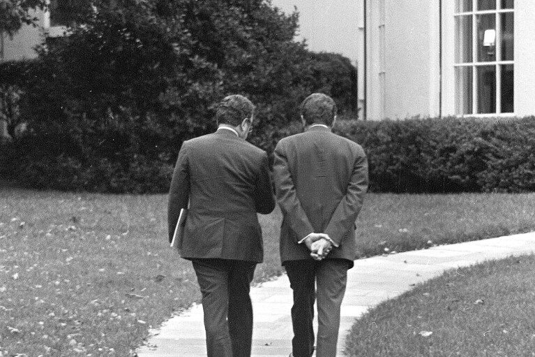 FILE - U.S. President Richard Nixon, right, and Secretary of State Henry Kissinger walk together to the White House in Washington, Oct. 31, 1973. Kissinger, the diplomat with the thick glasses and gravelly voice who dominated foreign policy as the United States extricated itself from Vietnam and broke down barriers with China, died Wednesday, Nov. 29, 2023. He was 100. (AP Photo, File)
