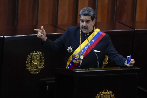 Venezuelan President Nicolas Maduro holds a small copy of his nation's constitution during ceremony marking the start of the judicial year at the Supreme Court in Caracas, Venezuela, Jan. 31, 2024.  (AP Photo/Ariana Cubillos, File)