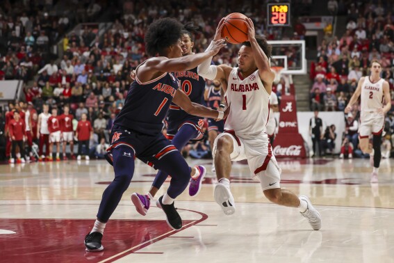 Alabama guard Mark Sears, right, drives against Auburn guard Aden Holloway during the first half of an NCAA college basketball game Wednesday, Jan. 24, 2024, in Tuscaloosa, Ala. (AP Photo/Vasha Hunt)