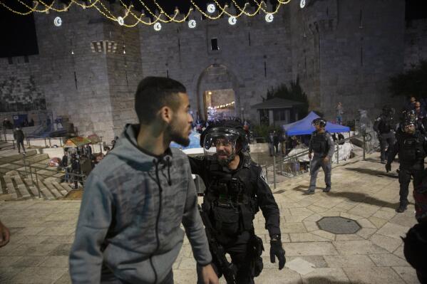 An Israeli policeman shouts at a Palestinian man to leave the Damascus Gate to the Old City of Jerusalem after clashes at the Al-Aqsa Mosque compound, Friday, May 7, 2021. Palestinian worshippers clashed with Israeli police late Friday at the holy site sacred to Muslims and Jews, in an escalation of weeks of violence in Jerusalem that has reverberated across the region. (AP Photo/Maya Alleruzzo)