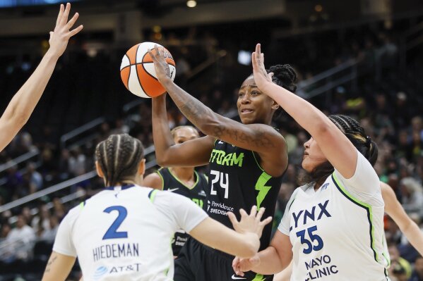 Seattle Storm guard Jewell Loyd passes the ball against the Minnesota Lynx defense during the first quarter of a WNBA basketball game Tuesday, May 14, 2024, in Seattle. (Jennifer Buchanan/The Seattle Times via AP)