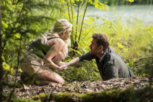 This image released by Prime shows Ashley Benson as Cara, left, and Oliver Jackson-Cohen as Will Taylor, in a scene from "Wilderness." (Kailey Schwerman/Prime via AP)