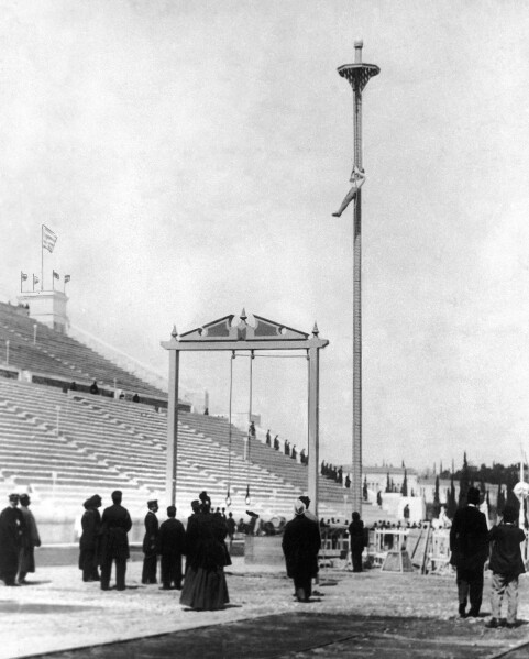 FILE - This April 10, 1896, file photo, shows Greek athlete Nikolaos Andriakopoulos on his way to winning the gold medal in the rope climbing event at the first modern Summer Olympic Games held at the Panathinaiko Stadium in Athens, Greece. From that modest start in Athens with 241 participants in 43 events, the Olympics have ballooned to include 11,238 athletes vying for 306 gold medals at the 2016 Games in Rio de Janeiro. More are expected for the Tokyo Olympics that were postponed one year because of the coronavirus pandemic. (AP Photo/File)
