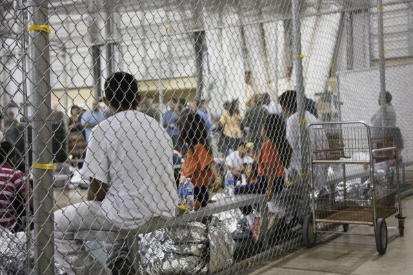 FILE - In this June 17, 2018, file photo provided by U.S. Customs and Border Protection, people who've been taken into custody related to cases of illegal entry into the United States, sit in one of the cages at a facility in McAllen, Texas. (U.S. Customs and Border Protection's Rio Grande Valley Sector via AP, File)