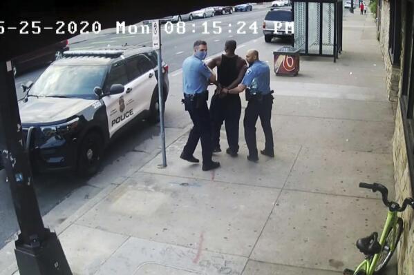 FILE - This image from video shows Minneapolis Police Officers Thomas Lane, left and J. Alexander Kueng, right, escorting George Floyd, center, to a police vehicle outside Cup Foods in Minneapolis, on May 25, 2020. The two and another former Minneapolis officers are on trial in February 2022, on federal civil rights charges in Floyd's death. All three are expected to testify. Kueng took the stand Wed. Feb. 16, 2022 in the trial. (Court TV via AP, Pool, File)