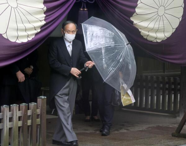 Former Japanese Prime Minister Yoshihide Suga leaves the Yasukuni Shrine in Tokyo Sunday, Oct. 17, 2021. Suga who stepped down at the end of September, prayed at the shrine during the shrine's autumn festival. The shrine is viewed by China and the Koreas as a symbol of Japanese wartime aggression. (Kyodo News via AP)