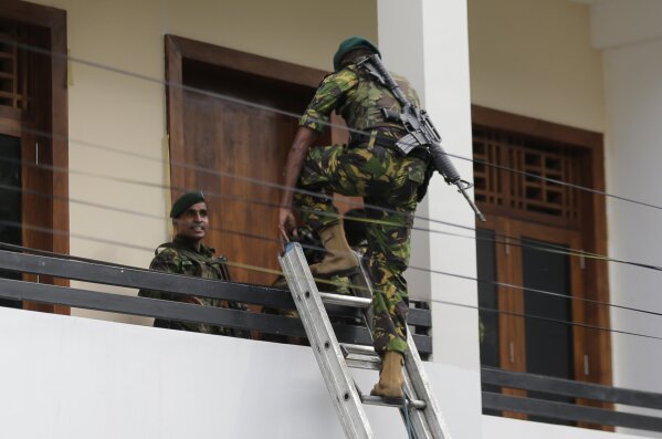 
              A Sri Lankan police commando enters a house suspected to be a hideout of militants following a shoot out in Colombo, Sri Lanka, Sunday, April 21, 2019.  More than hundred were killed and hundreds more hospitalized with injuries from eight blasts that rocked churches and hotels in and just outside of Sri Lanka's capital on Easter Sunday, officials said, the worst violence to hit the South Asian country since its civil war ended a decade ago. (AP Photo/Eranga Jayawardena)
            