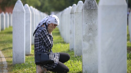 A Bosnian muslim woman mourns next to the grave of her relative, victim of the Srebrenica genocide, at the Memorial Centre in Potocari, Bosnia, Tuesday, July 11, 2023. Thousands gahter in the eastern Bosnian town of Srebrenica to commemorate the 28th anniversary on Monday of Europe's only acknowledged genocide since World War II. (AP Photo/Armin Durgut)
