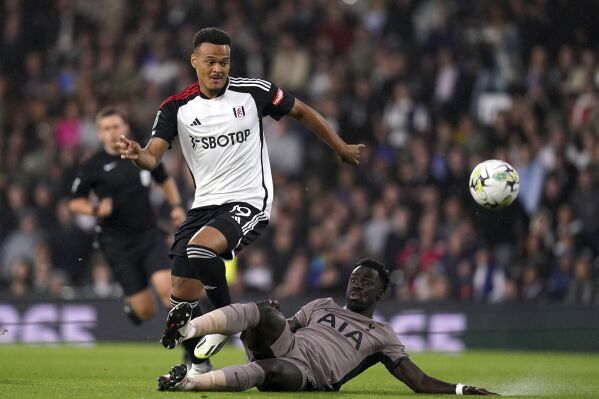 Fulham's Rodrigo Muniz, left, and Tottenham Hotspur's Davinson Sanchez battle for the ball during the Carabao Cup second round soccer match at Craven Cottage, London, Tuesday Aug. 29, 2023. (John Walton/PA via AP)