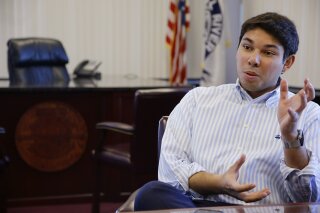 FILE- In this Jan. 6, 2016, file photo newly elected Fall River Mayor Jasiel Correia talks in his city hall office in Fall River, Mass. A Massachusetts mayor was arrested Thursday, Oct. 11, 2018, and charged with defrauding investors in a company he formed out of more than $230,000 and using the funds to enhance his political career and pay for a lavish lifestyle, federal prosecutors said. (AP Photo/Stephan Savoia, File)