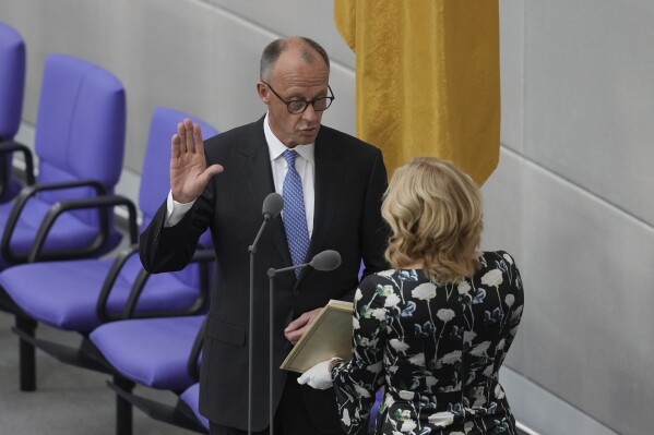 Friedrich Merz takes the oath of office in front of Parliament President Julia Kloeckner after being elected new Chancellor at the German federal parliament, Bundestag, at the Reichstag building in Berlin, Germany, Tuesday, May 6, 2025. (AP Photo/Markus Schreiber)