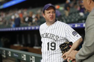 FILE--In this Friday, June 14, 2019, file photograph, Colorado Governor Jared Polis prepares to throw out the ceremonial first pitch before the Colorado Rockies host the San Diego Padres in Denver. (AP Photo/David Zalubowski, File)