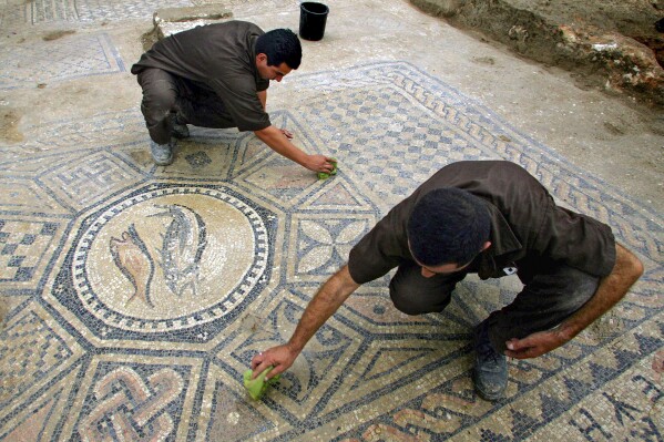 File - Prisoners work at a nearly 1,800-year-old decorated floor from an early Christian prayer hall discovered by Israeli archaeologists on Sunday, November 6, 2005 in the Megiddo prison. Israeli officials are considering uprooting the mosaic and loaning it to the controversial Museum of the Bible in Washington D.C., a proposal that has upset archaeologists and underscores the hardline government's close ties with evangelical Christians in the U.S. (AP Photo/Ariel Schalit, File)