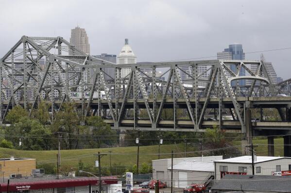 FILE - Traffic on the Brent Spence Bridge passes in front of the Cincinnati skyline while crossing the Ohio River to and from Covington, Ky., Oct. 7, 2014. According to a recent announcement by Kentucky and Ohio they will receive more than $1.63 billion in federal grants to help build a new Ohio River bridge near Cincinnati and improve the existing overloaded span there, a heavily used freight route linking the Midwest and the South. (AP Photo/Al Behrman, File)