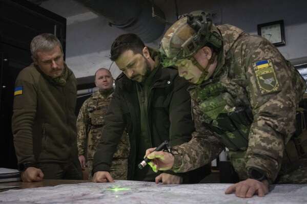 FILE - Ukrainian President Volodymyr Zelenskyy, Commander of Ukraine's Ground Forces Col.-Gen. Oleksandr Syrski, right, look at a map during their visit to the front line city of Kupiansk, Kharkiv region, Ukraine, on Nov. 30, 2023. Ukraine’s commander in chief, Oleksandr Syrski, said Russia’s top military leadership ordered its soldiers to capture the town of Chasiv Yar by May 9, Russia’s Victory Day, a holiday that marks the defeat of Nazi Germany. (AP Photo/Efrem Lukatsky, File)