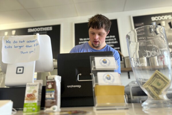 FILE - Patrick Chapman, 27, prepares for customers Thursday, March 2, 2023, at The Golden Scoop, an Overland Park, Kan., ice cream and coffee shop that employs workers with developmental disabilities, paying them more than minimum wage. Kansas is poised to expand an income tax credit for goods and services purchased from companies and nonprofits employing disabled workers, a year after a debate over how much the state should buck a national trend against paying those workers below the minimum wage. (AP Photo/Heather Hollingsworth, File)
