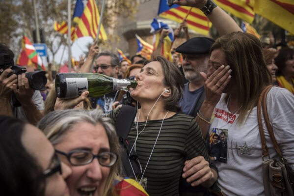 
              People wave "estelada" or pro independence flags celebrating in the street in Barcelona, Spain, after Catalonia's regional parliament passed a motion with which they say they are establishing an independent Catalan Republic, Friday, Oct. 27, 2017. (AP Photo/Santi Palacios)
            
