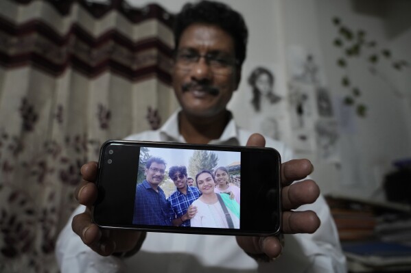Gautam Dongre, of the National Alliance of Sickle Cell Organizations, shows a photograph his family, including his son, Girish, second left, and daughter, Sumedha, right, both patients of sickle cell disease, in Nagpur, India, Wednesday, Dec. 6, 2023. Dongre said he hopes gene therapy for sickle cell eventually makes it to India. If it does, he’d like his children to be among the first to get it. (AP Photo/Ajit Solanki)