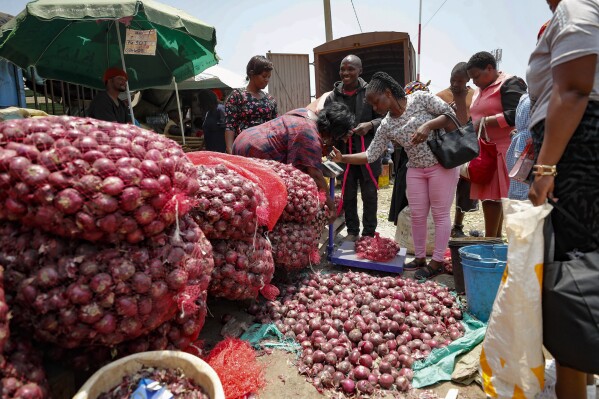 People buy onions at an open market in Nairobi, Kenya Tuesday, Sept. 12, 2023. Restrictions on the export of the vegetable by neighboring Tanzania has led prices to triple. Some traders have adjusted by getting produce from Ethiopia. (AP Photo/Brian Inganga)
