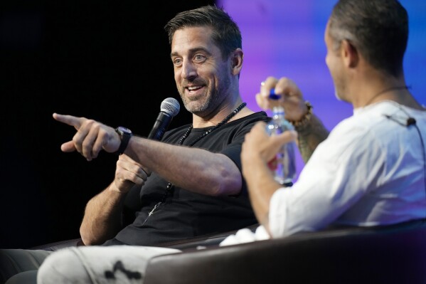 New York Jets quarterback Aaron Rodgers, back, chats with entrepreneur Aubrey Marcus during a program at the Psychedelic Science conference in the Colorado Convention Center Wednesday, June 21, 2023, in Denver. (AP Photo/David Zalubowski)