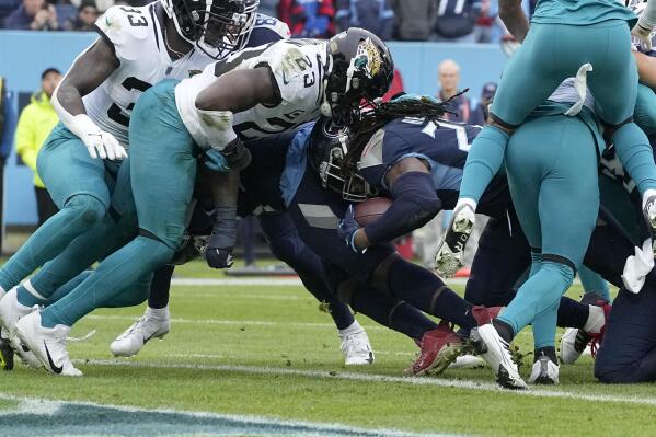 Tennessee Titans running back Derrick Henry slips into the end zone for a touchdown past Jacksonville Jaguars linebacker Foyesade Oluokun (23) during the first half of an NFL football game Sunday, Dec. 11, 2022, in Nashville, Tenn. (AP Photo/Chris Carlson)