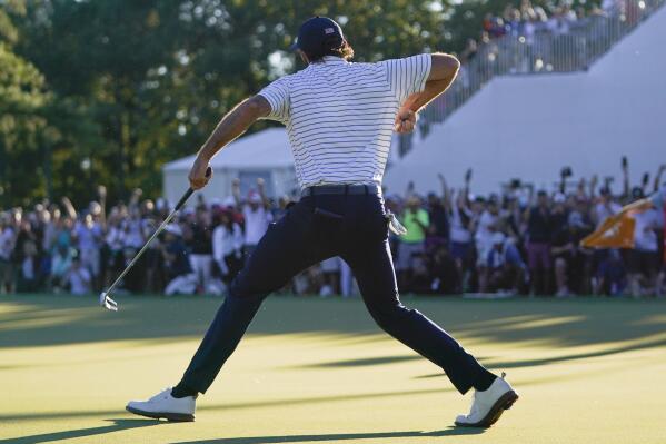 Max Homa celebrates winning the 18th hole during their fourball match at the Presidents Cup golf tournament at the Quail Hollow Club, Friday, Sept. 23, 2022, in Charlotte, N.C. (AP Photo/Julio Cortez)