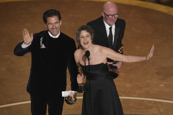 Clement Ducol, from left, Camille, and Jacques Audiard, accept the award for best original song for "El Mal" from" Emilia Perez" during the Oscars on Sunday, March 2, 2025, at the Dolby Theatre in Los Angeles. (AP Photo/Chris Pizzello)