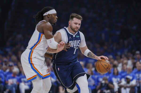 Dallas Mavericks guard Luka Doncic, right, drives against Oklahoma City Thunder guard Luguentz Dort during the first half of Game 1 of an NBA basketball second-round playoff series, Tuesday, May 7, 2024, in Oklahoma City. (AP Photo/Nate Billings)