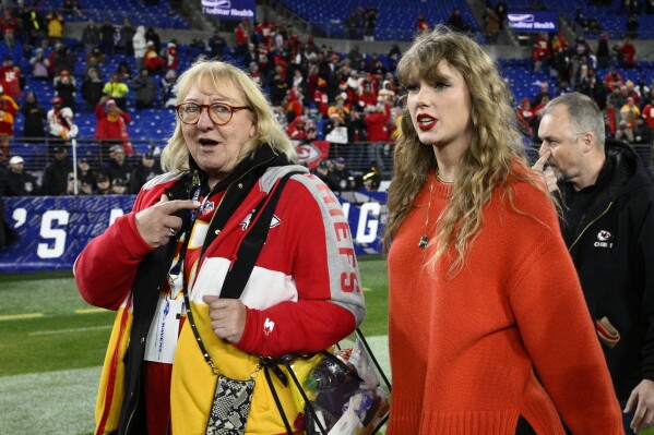 Taylor Swift, right, walks with Donna Kelce on the field after the AFC Championship NFL football game between the Baltimore Ravens and the Kansas City Chiefs, Sunday, Jan. 28, 2024, in Baltimore. (AP Photo/Nick Wass)