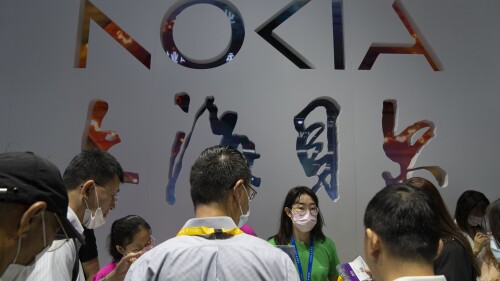 Visitors talk to staff members at a display for technology firm Nokia at the PT Expo in Beijing, Sunday, June 4, 2023. The annual expo showcases Chinese and foreign technology firms. (AP Photo/Mark Schiefelbein)
