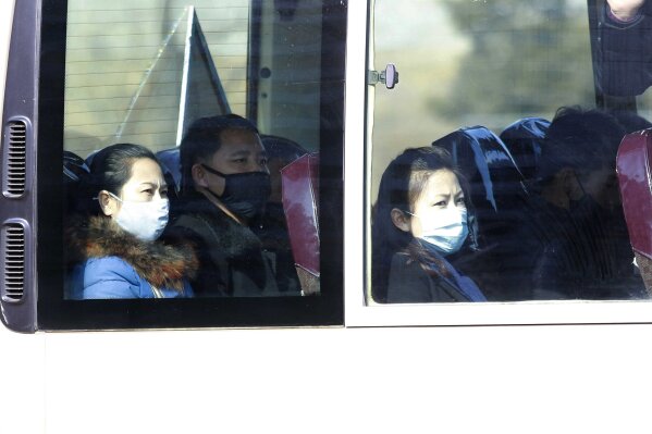FILE - In this Feb. 26, 2020, file photo, people wear masks as they ride on a public bus in Pyongyang, North Korea. As a new and frightening virus closes in around it, North Korea presents itself as a fortress, tightening its borders as cadres of health officials stage a monumental disinfection and monitoring program. (AP Photo/Jon Chol Jin, File)