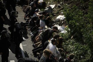 FILE - In this June 1, 2020 file photo, police detain protesters in the aftermath of a march calling for justice over the death of George Floyd on Interstate 676 in Philadelphia. An independent review of Philadelphia’s police response to days of widespread protests over police brutality after the May killing of George Floyd found failures in planning that led to short staffing, emotional responses from police officers and sometimes excessive uses of force. The 110-page report released Wednesday, Dec. 23, was commissioned by Mayor Jim Kenney as an independent review of operations during the protests. (AP Photo/Matt Rourke, File)