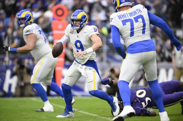 Los Angeles Rams quarterback Matthew Stafford (9) avoids a sack attempt by Baltimore Ravens outside linebacker Justin Houston (50) during the first half of an NFL football game, Sunday, Jan. 2, 2022, in Baltimore. (AP Photo/Nick Wass)