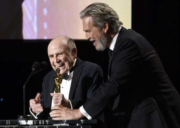 FILE - In this Saturday, Nov. 12, 2016 file photo, Honoree Lynn Stalmaster, left, collects his award from actor Jeff Bridges onstage at the 2016 Governors Awards at the Dolby Ballroom in Los Angeles .Lynn Stalmaster, the Oscar-winning casting director whose eye for talent helped launch the careers of John Travolta, Christopher Reeve, Richard Dreyfuss and many other actors, has died. He was 93. (Photo by Chris Pizzello/Invision/AP, File)