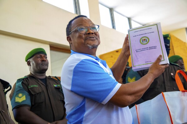 Tanzania's main opposition leader Tundu Lissu, holds up a proposed constitutional document at Kisutu magistrate's court in Dar es Salaam, Tanzania Monday, May 19, 2025. (AP Photo/Derick Katunzi)
