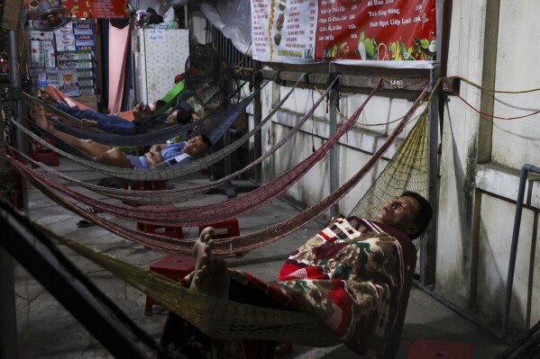 Fishers sleep at the Da Nang harbor on March 5, 2025, in Da Nang, Vietnam. (AP Photo/Yannick Peterhans)