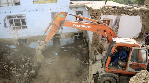 An excavator removes mud from a damaged house after heavy flooding in the Maidan Wardak province in the central of Afghanistan, Sunday, July 23, 2023. Heavy flooding from seasonal rains in Afghanistan killed multiple people and left dozens missing over the past three days. (AP Photo)