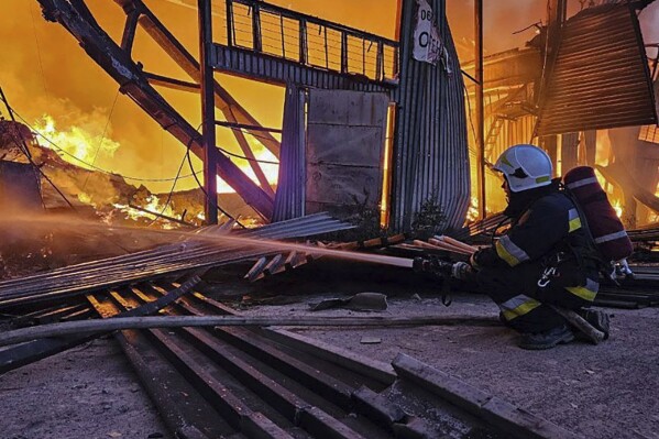 In this photo provided by the Ukrainian Emergency Service, emergency services personnel work to extinguish a fire following a Russian attack in Lviv, Ukraine, Tuesday, Sept. 19, 2023. (Ukrainian Emergency Service via AP)
