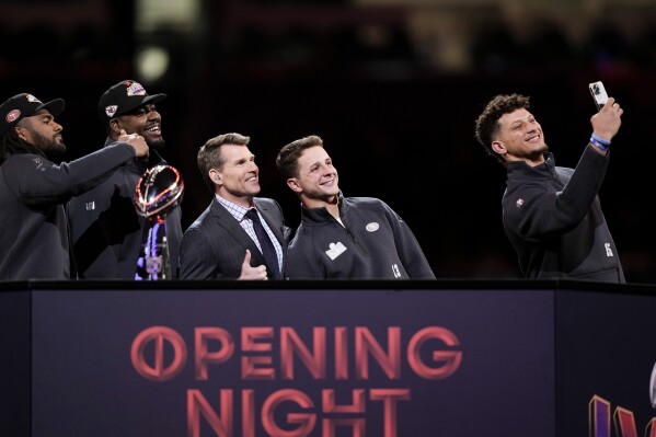 Kansas City Chiefs quarterback Patrick Mahomes (15) takes a photograph with San Francisco 49ers quarterback Brock Purdy (13), NFL Network's Scott Hanson, center, Kansas City Chiefs' Chris Jones (95) and San Francisco 49ers' Fred Warner, left, during the NFL football Super Bowl 58 opening night Monday, Feb. 5, 2024, in Las Vegas. The San Francisco 49ers will play the Kansas City Chiefs in Super Bowl 58 Sunday. (APPhoto/Charlie Riedel)