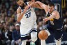 Denver Nuggets center Nikola Jokic, right, pushes Minnesota Timberwolves center Rudy Gobert while they pursue the ball during the second half of an NBA basketball game Wednesday, April 10, 2024, in Denver. (AP Photo/David Zalubowski)