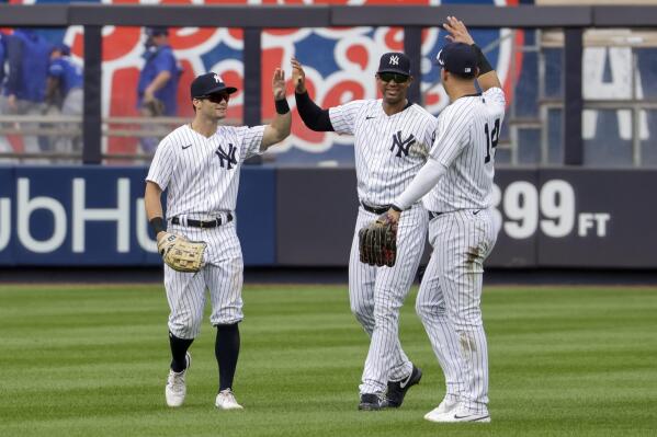 New York Yankees' Andrew Benintendi, left, Aaron Hicks, center, and Marwin Gonzalez celebrate after their win over the Toronto Blue Jays in a baseball game Sunday, Aug. 21, 2022, in New York. (AP Photo/Corey Sipkin)