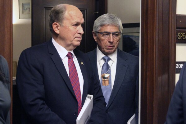 FILE - In this Thursday, Jan. 18, 2018 file photo, Alaska Gov. Bill Walker, left, and Lt. Gov. Byron Mallott wait for a joint session of the Alaska Legislature to convene in Juneau, Alaska.An email from Alaska’s former first lady sheds new light on the actions that drove Lt. Gov. Byron Mallott from office, suggesting he may have invited a woman into his room, newly released emails shows. (AP Photo/Mark Thiessen, File)