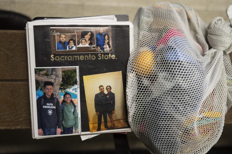 Waterdrops sit on the surface of Gerald Massey's binder with his family photos as Massey works in a barbershop at Folsom State Prison in Folsom, Calif., Thursday, May 4, 2023. Massey earned his bachelor's degree in communications through the Transforming Outcomes Project at Sacramento State. Many more prisoners like Massey will have opportunities to leave prison with bachelor's degrees, when new federal rules on financial aid for higher education take effect in July. (AP Photo/Jae C. Hong)
