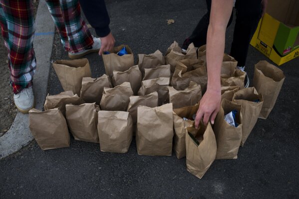 
              Young volunteers from Lion's Heart, a non-profit community service organization, prepare sack lunches for homeless people Thursday, Dec. 21, 2017, in Dana Point, Calif. (AP Photo/Jae C. Hong)
            