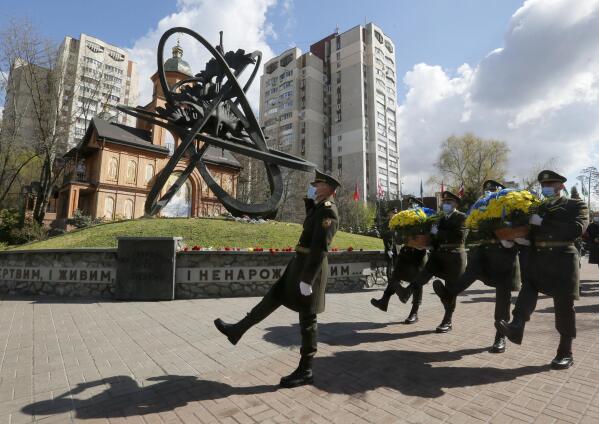Guards of Honor march to lay a flower wreath at Chernobyl's victim monument in Ukraine's capital Kyiv, Ukraine, Monday, April 26, 2021. April 26 marks the 35th anniversary of the Chernobyl nuclear disaster. A reactor at the Chernobyl nuclear power plant exploded on April 26, 1986, leading to an explosion and the subsequent fire spewed a radioactive plume over much of northern Europe. (AP Photo/Efrem Lukatsky)