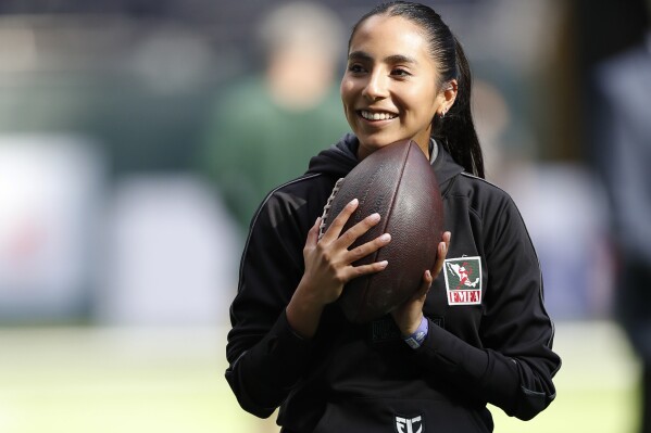 FILE - Team Mexico Women's Flag quarterback Diana Flores stands on the field before an NFL football game between the Green Bay Packers and the New York Giants at Tottenham Hotspur Stadium in London, Sunday, Oct. 9, 2022. (AP Photo/Steve Luciano, File)