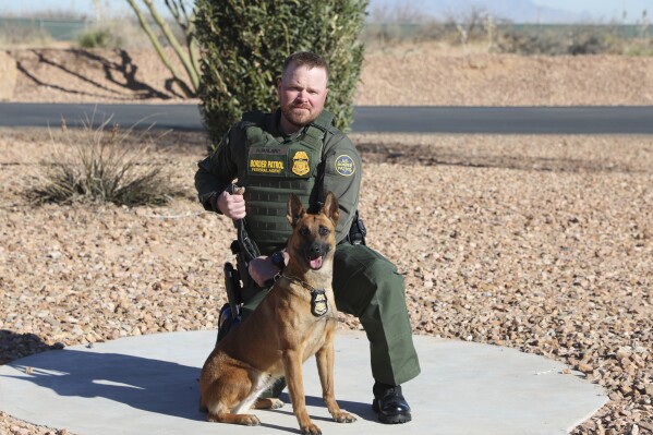 In this undated and unknown location photo released by the Department of Homeland Security shows Border Patrol Agent David Maland posing with a service dog. (Department of Homeland Security via AP, File)