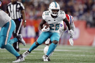FILE - Miami Dolphins running back De'Von Achane (28) plays against the New England Patriots during an NFL football game, Sunday, Sept. 17, 2023, in Foxborough, Mass. Miami rookie running back De’Von Achane returned to practice Monday, Nov. 13, after missing the past four games with a knee injury.(APPhoto/Michael Dwyer, File)