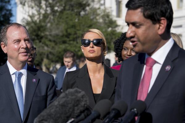 Hotel heiress and reality star Paris Hilton, flanked by House Intelligence Committee Chairman Adam Schiff, D-Calif., left, and Rep. Ro Khanna, D-Calif., lends her celebrity to support legislation to establish a bill of rights for children placed in congregate care facilities, at the Capitol on Wednesday, Oct. 20, 2021. Hilton says she was traumatized as a teenager when she was sent by her family to abusive care facilities. (AP Photo/J. Scott Applewhite)