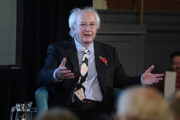 Sir Philip Pullman speaks at the Sheldonian Theatre, Oxford University, England, Thursday Nov. 9, 2023. Fans of Philip Pullman have been waiting almost five years for the final instalment in the author’s sextet of books about his intrepid heroine Lyra and her adventures in multiple worlds. They won’t have to wait too much longer. Pullman says he has written 500 pages of a 540-page novel to conclude the “Book of Dust” trilogy, and it should be published next year. He he still doesn’t have a title. (Andrew Matthews/PA via AP)